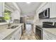Modern kitchen features stainless steel appliances, granite countertops, and white cabinets, creating a sleek and functional space at 5144 Orange Ave, Winter Park, FL 32792