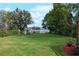 Spacious backyard with lush green lawn, mature trees, and a waterfront shed offering serene lake views at 5301 Pineview Way, Apopka, FL 32703
