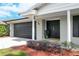 Front entrance showcasing the gray brick exterior, dark double doors, and manicured landscaping at 5301 Pineview Way, Apopka, FL 32703