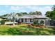 Attractive home with a lush lawn, landscaping, and a white-painted brick exterior with black shutters at 5301 Pineview Way, Apopka, FL 32703