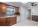 Kitchen featuring tile floors, wood cabinets, and a clean white dishwasher at 622 Mount Homer Rd # 622, Eustis, FL 32726