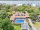 Aerial view of a home featuring a screened-in pool and lush greenery near the water at 639 John Anderson Dr, Ormond Beach, FL 32176