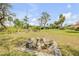 Spacious backyard featuring lush greenery, a stone bench, and a charming view of the serene surrounding landscape at 639 John Anderson Dr, Ormond Beach, FL 32176