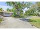 Curving concrete driveway to a house with a covered garage, complemented by a well-manicured lawn and mature trees at 639 John Anderson Dr, Ormond Beach, FL 32176