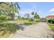 Long concrete driveway leads to a house and carport, surrounded by green lawns, mature trees, and lush landscaping at 639 John Anderson Dr, Ormond Beach, FL 32176