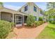 Beautiful home featuring a screened-in porch, brick walkway, white exterior, and classic blue shutters at 639 John Anderson Dr, Ormond Beach, FL 32176