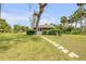 Charming cottage with a stone path leading to the front porch, surrounded by a green lawn and mature trees at 639 John Anderson Dr, Ormond Beach, FL 32176