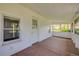Enclosed porch with wood floors, white walls and trim, and lots of windows for natural light and fresh air at 639 John Anderson Dr, Ormond Beach, FL 32176