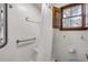 Bright shower features grab bars, a shower chair, and a window for light and ventilation at 639 John Anderson Dr, Ormond Beach, FL 32176