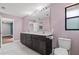 Bathroom with marble countertop, dual sinks, dark wood cabinets and toilet at 6402 Beechnut Dr, Lakeland, FL 33813