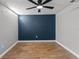 A spacious bedroom features wood-style flooring, ceiling fan and a blue accent wall at 6402 Beechnut Dr, Lakeland, FL 33813