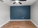 A spacious bedroom features wood-style flooring, ceiling fan and a blue accent wall at 6402 Beechnut Dr, Lakeland, FL 33813