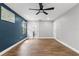 Spacious bedroom featuring sleek ceiling fan, wood flooring, and a striking blue accent wall at 6402 Beechnut Dr, Lakeland, FL 33813