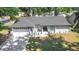 Inviting single-story home featuring a new roof, updated white brick exterior and a spacious, tree-filled front lawn at 6402 Beechnut Dr, Lakeland, FL 33813
