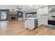 Open concept living room with a brick fireplace, modern kitchen and hardwood floors at 6402 Beechnut Dr, Lakeland, FL 33813