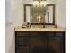 Bathroom with granite countertops, dark wood cabinets, and a large framed mirror at 741 Mystic Oaks Ln, Deland, FL 32724