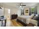 Cozy bedroom with wood-look floors, two windows with curtains, and a ceiling fan at 741 Mystic Oaks Ln, Deland, FL 32724