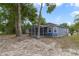 Exterior view of a blue home featuring a screened porch and mature trees at 741 Mystic Oaks Ln, Deland, FL 32724