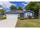 Charming single-story home with blue siding, manicured lawn, and a two-car garage at 741 Mystic Oaks Ln, Deland, FL 32724