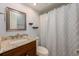 Bathroom featuring a granite countertop vanity and bathtub with patterned shower curtain at 7423 Elsworth Ct, Orlando, FL 32819