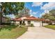 Charming single-story home with a well-manicured lawn, mature trees, and an attached garage in a lovely neighborhood at 7423 Elsworth Ct, Orlando, FL 32819