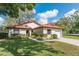 Charming single Gathering home featuring a well-manicured lawn and mature trees at 7423 Elsworth Ct, Orlando, FL 32819