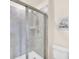 Bathroom features a walk-in shower, sleek glass enclosure, and neutral tile, with a Harry Potter owl decoration at 7487 Oakmoss Loop, Davenport, FL 33837