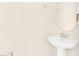 Elegant half bathroom with a round mirror and pedestal sink, and tile flooring at 7487 Oakmoss Loop, Davenport, FL 33837