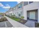 Charming townhome featuring a gray exterior, aqua shutters, and a well-maintained front lawn at 7487 Oakmoss Loop, Davenport, FL 33837