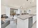 Spacious kitchen with granite countertop island overlooking the open-concept living area and backyard patio at 7487 Oakmoss Loop, Davenport, FL 33837