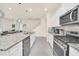 Well-equipped kitchen with granite counters, stainless steel appliances and an island that opens up to the living area at 7487 Oakmoss Loop, Davenport, FL 33837