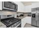 Close up on gourmet kitchen with stainless appliances, granite counters, and white cabinets at 7487 Oakmoss Loop, Davenport, FL 33837