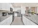 Modern kitchen with a large island, stainless steel appliances, and sleek white cabinets at 7487 Oakmoss Loop, Davenport, FL 33837