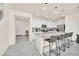 Bright kitchen with white cabinetry, granite countertops, stainless steel appliances, and barstool seating at island at 7487 Oakmoss Loop, Davenport, FL 33837