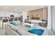 Open concept living room featuring bar seating, sleek furniture, and a decorative accent wall at 7487 Oakmoss Loop, Davenport, FL 33837
