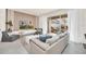 Bright living room with modern decor, neutral tones, large sliding glass doors to the screened-in patio at 7487 Oakmoss Loop, Davenport, FL 33837