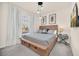Cozy main bedroom with large window and decorative lighting, a flat-screen television, and plush bedding at 7487 Oakmoss Loop, Davenport, FL 33837