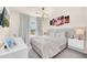 Serene bedroom with a large bed, stylish lighting, modern furnishings, and a view of the outdoors at 7487 Oakmoss Loop, Davenport, FL 33837