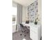 Modern office space with white desk, gray chair, and decorative wallpaper at 7487 Oakmoss Loop, Davenport, FL 33837