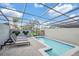 Private screened-in pool area with gray brick pavers, lounge chairs, and whimsical Mickey Mouse shrubbery at 7487 Oakmoss Loop, Davenport, FL 33837