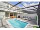 Inviting pool area features covered patio, outdoor seating, and an exterior view of the home and neighborhood at 7487 Oakmoss Loop, Davenport, FL 33837