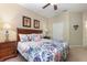 Comfortable bedroom featuring a floral comforter, side tables, and ceiling fan at 7654 Comrow St # 104, Kissimmee, FL 34747