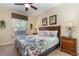 Inviting bedroom with a floral comforter, side tables, and a bright, sunny window at 7654 Comrow St # 104, Kissimmee, FL 34747