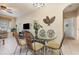 Bright dining room with a glass table, seating for six, and decorative leaf wall art at 7654 Comrow St # 104, Kissimmee, FL 34747