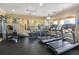 Well-equipped fitness center with treadmills, stationary bikes, weight machines, and large windows with neighborhood views at 7654 Comrow St # 104, Kissimmee, FL 34747