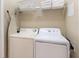 Functional laundry room with washer, dryer, ironing board, and shelving at 7654 Comrow St # 104, Kissimmee, FL 34747