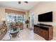 Well-lit living room features a flatscreen TV, large window, and neutral tones at 7654 Comrow St # 104, Kissimmee, FL 34747