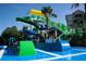 Community waterslide featuring a spiral slide, a straight slide, and a splash pool with palm trees and lush landscaping at 7654 Comrow St # 104, Kissimmee, FL 34747