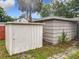 Backyard featuring two sheds, lush grass, and mature trees at 810 Catalina Dr, Sanford, FL 32771