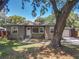 Traditional home with mature trees, features a white front door, symmetrical window placement, and a well-kept lawn at 810 Catalina Dr, Sanford, FL 32771